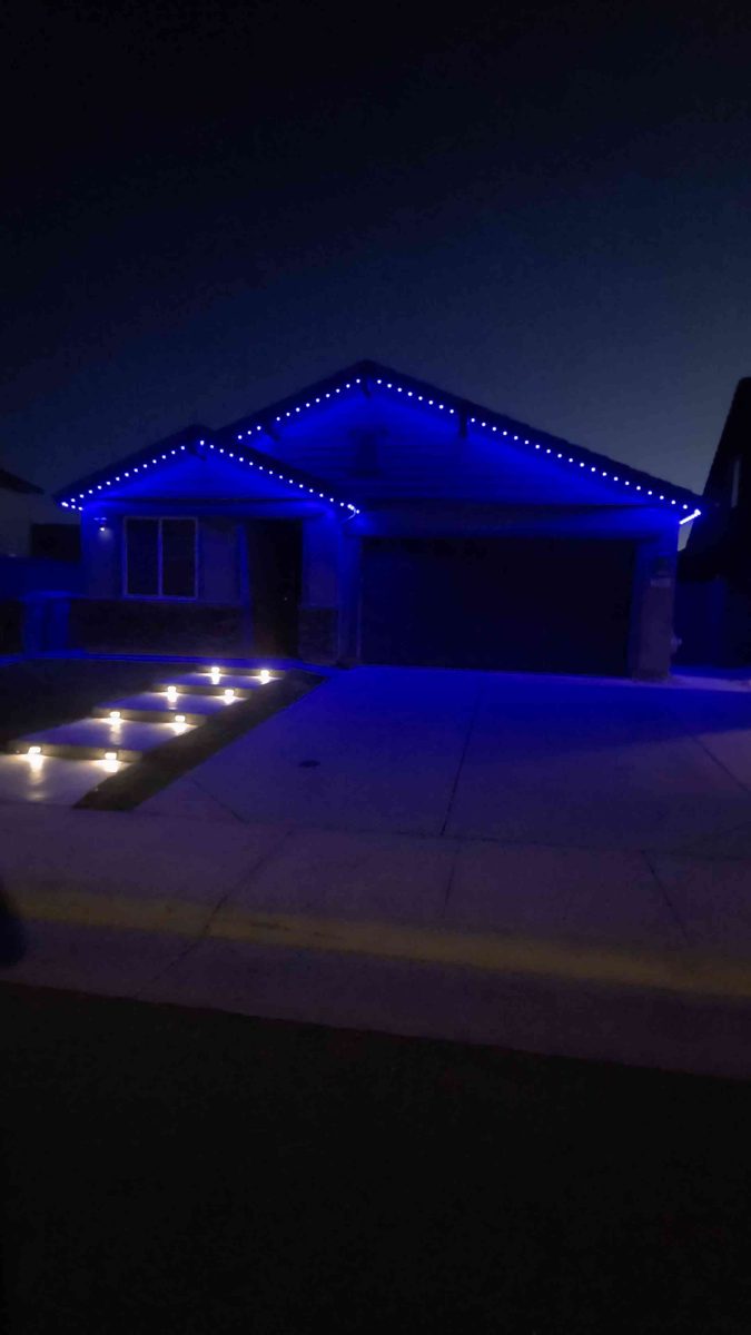 Home lit in blue permanent lighting with path lights